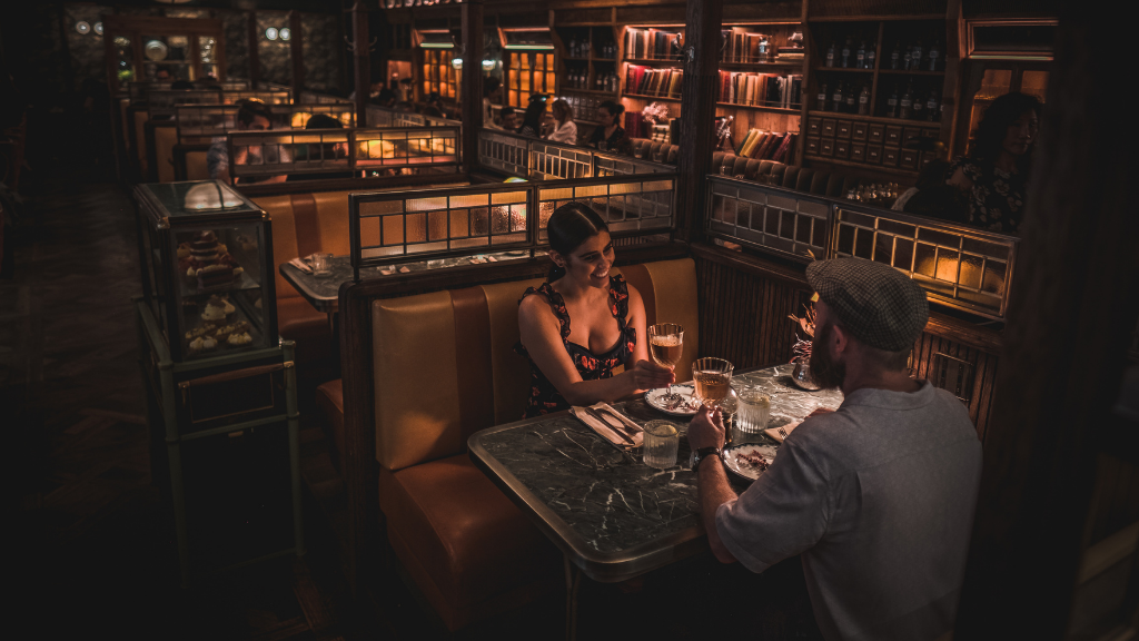 Guests dining in a warm booth at The Grounds of The City