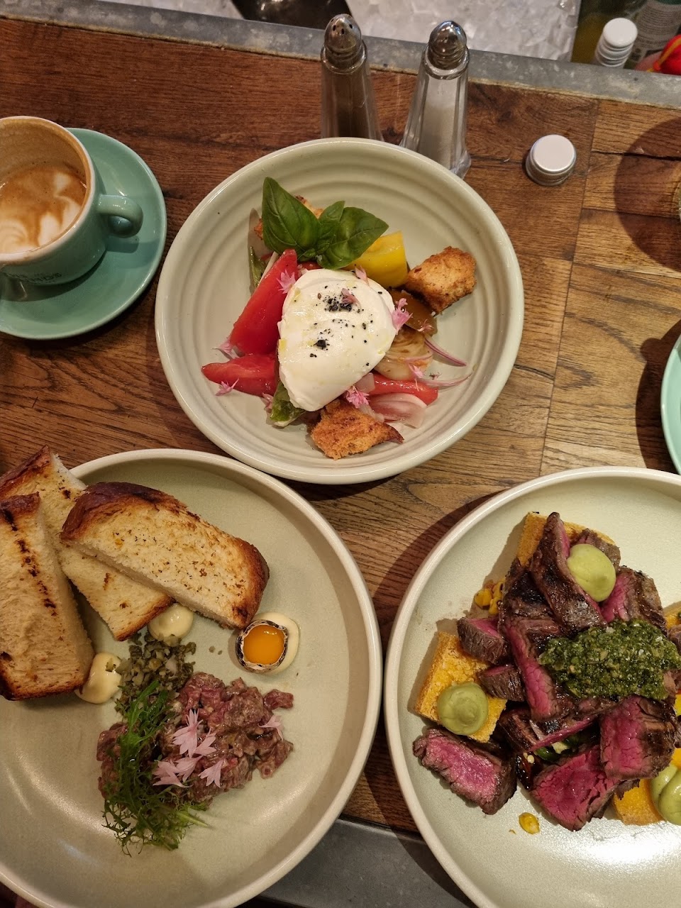 Several shared plates and coffee on a table